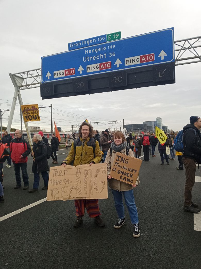 Onder een snelwegbord met 'Groningen' erop. 